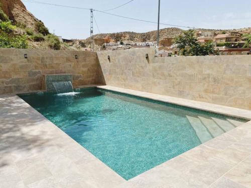 Graena3 bedrooms property with private pool at Cortes y Graena的一座带石墙的游泳池