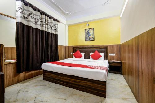 西姆拉Woods Imperial Kufri的一间卧室配有一张带红色枕头的大床