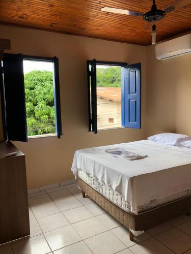 伦索伊斯Pousada Brilho da Chapada New的一间卧室设有一张床和两个窗户。