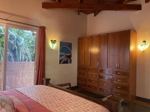 西湾Casa Maya的一间卧室配有一张床、一个梳妆台和一扇窗户。