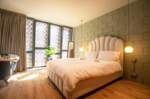 曼彻斯特Luxury Roof Terrace Townhouse的卧室设有白色大床和窗户。