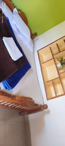 马迪凯里Madhuvana Guest House的一张带镜子的壁床