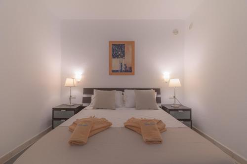 普拉亚布兰卡Playa Flamingo C的一间卧室配有一张带两盏灯的大型白色床。