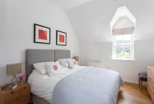 珀斯Stalker's Lodge的卧室配有白色床单和窗户。