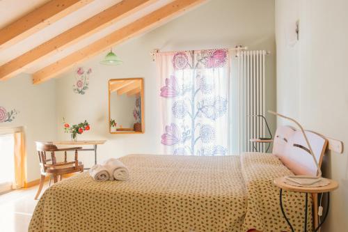 科莫卡萨迪玛利亚旅馆的一间卧室配有一张床、一张桌子和一面镜子