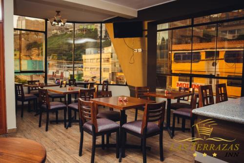 安达韦拉斯HOTEL LAS TERRAZAS INN的餐厅设有桌椅,窗户上设有一辆巴士