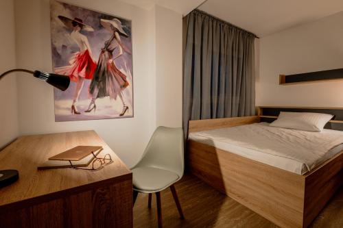 诺伊斯Jade&Jabo - Moderne möblierte Serviced Apartments - Düsseldorf-Neuss的一间卧室配有一张床和一张带台灯的书桌