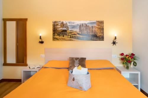 利维尼奥Mountain Apartments Livigno的一间卧室配有橙色的床,上面装有袋子