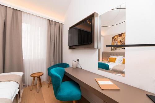 Donji HumacHotel Sveta Ana的酒店客房配有书桌和床。