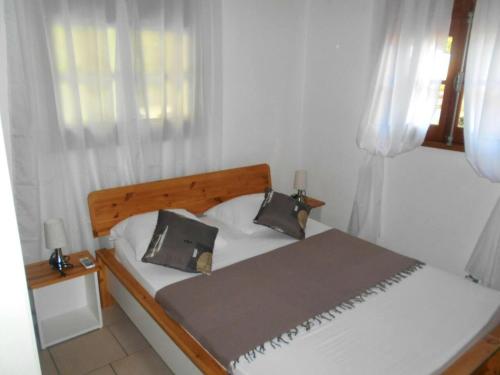 德赛Villa de 2 chambres a Deshaies a 400 m de la plage avec jacuzzi terrasse et wifi的卧室内的一张带两个枕头的床