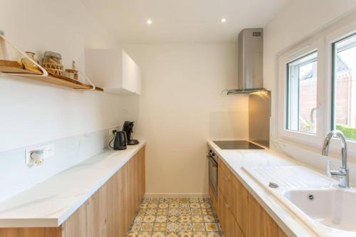 亚眠Appartement d'une chambre avec wifi a Amiens的厨房配有白色的柜台、水槽和窗户。