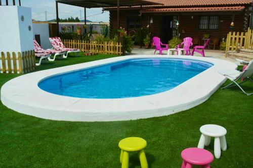 阿达莱斯3 bedrooms chalet with shared pool and wifi at Ardales的一座游泳池,四周环绕着凳子