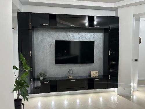 北马马亚-讷沃达里New Eva Unique Luxury Apartament的墙上有电视的黑色娱乐中心