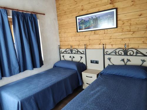 Olocau del ReyEl Freginal的配有蓝色床单的客房内的两张床