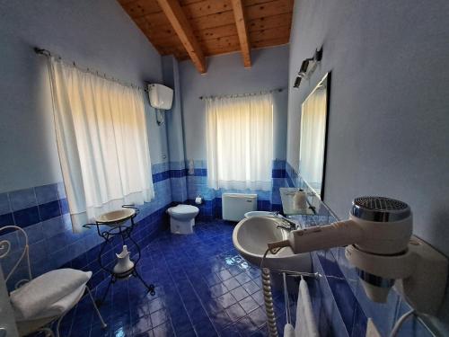 MergoAgriturismo Colle delle Stelle的蓝色瓷砖浴室设有水槽和卫生间