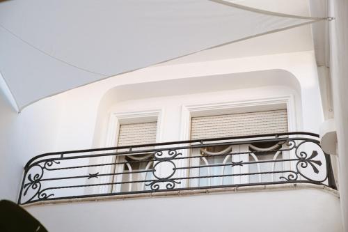 图里ALBERGO DIFFUSO Dimora Rossi Charme的白色建筑的阳台,带有窗户
