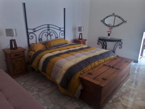 瓜达拉哈拉Casa Rosa Amelia的一间卧室配有一张位于尽头的木箱床