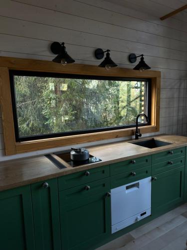 ZhurakyThe Sunset Cabin будиночок з Чаном的厨房设有水槽和位于柜台上方的窗户