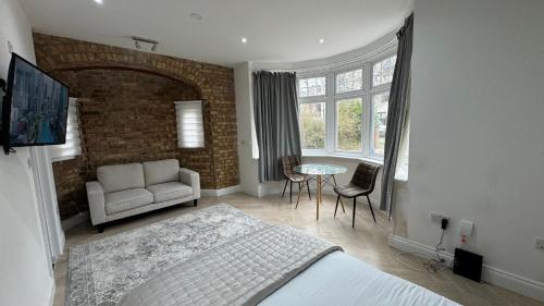 哈罗London Studios and Suites的一间卧室配有一张床、一张沙发和一张桌子