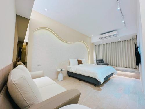 台南Enjoy Homestay的酒店客房,配有床和沙发