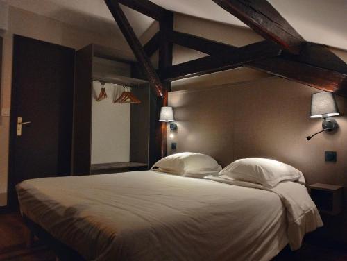 蒙特勒伊HÔTEL ROYAL MONTREUIL的卧室配有一张带两个枕头的大白色床