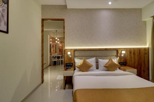 孟买Home2 Studio Apartments的卧室配有带金色枕头的大型白色床