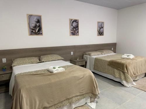 沙帕达-杜斯吉马朗伊斯POUSADA ACONCHEGO MT的一间卧室配有两张带毛巾的床