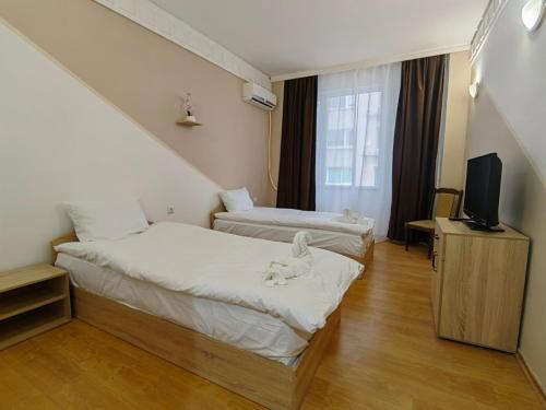VratsaХотел Приятели的一间酒店客房,设有两张床和电视
