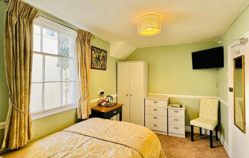 韦茅斯The Angove的一间卧室配有一张床、一张书桌和一个窗户。