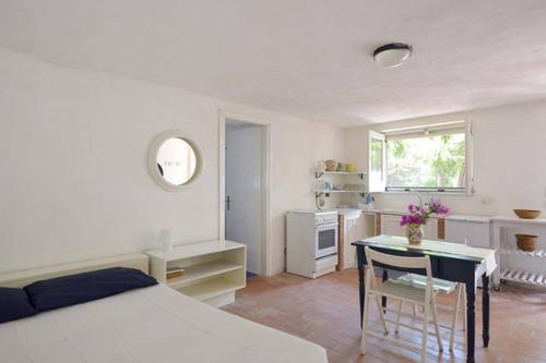 利卡塔Villa Caterina的一间卧室配有一张床铺和一张桌子,还设有一间厨房