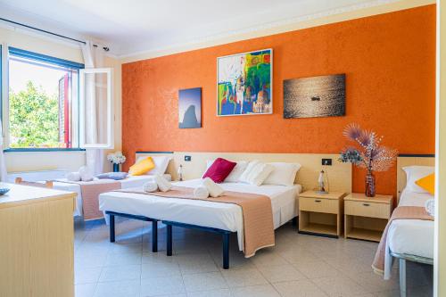 圣凯撒利亚温泉Hotel Le Macine的一间卧室设有两张床,拥有橙色的墙壁。
