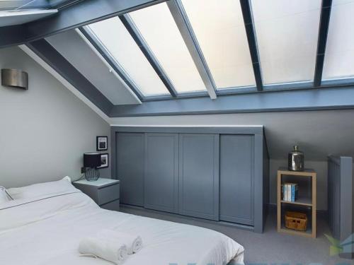 布杰斯希尔Spacious open planned 1 bedroom apartment的卧室配有白色的床和天窗