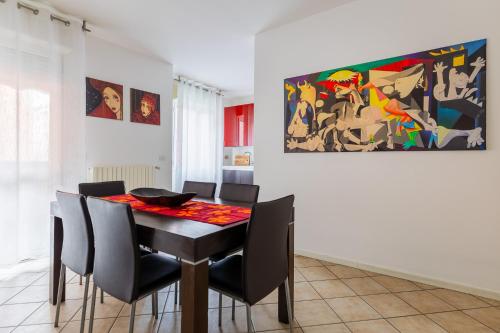 博洛尼亚Casa Pibe de oro Bologna Fiera的用餐室配有桌椅和绘画作品