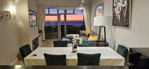 开普敦Beachfront 3-bedroom with Robben Island views的客厅配有桌椅和沙发
