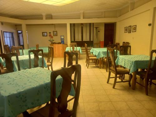 波托西HOTEL NOBLEZA的用餐室配有桌椅和绿色的桌布