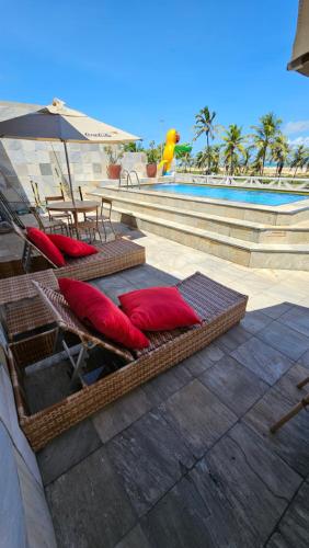 阿拉卡茹贾托巴海滩酒店的游泳池畔的2把躺椅和遮阳伞