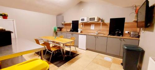 多尔盖罗Private Room at Torrent Walk Bunkhouse in Snowdonia的一个带桌子和黄色椅子的小厨房