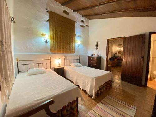 CurvatosSerra do Caldeirao Villa with Pool的一间卧室,配有两张床