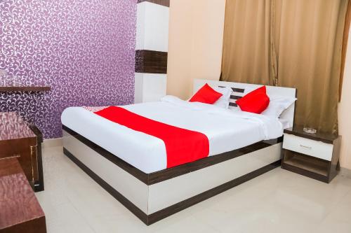 阿加尔塔拉OYO Hotel Sonar Gaon的一间卧室配有一张带红色枕头的大床