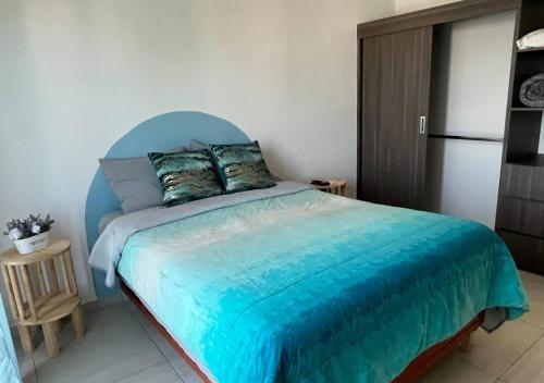 韦拉克鲁斯Departamento climatizado excelente ubicación的一间卧室配有一张蓝色床头板的床