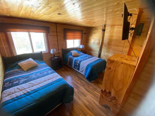 锡斯内斯港Hospedaje Alto Palena de Puerto Cisnes的小木屋内一间卧室,配有两张床