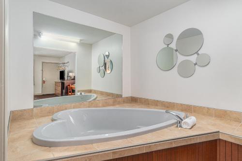 特拉弗斯城特拉弗斯城霍华德约翰逊酒店的一个带镜子的浴室内的大浴缸