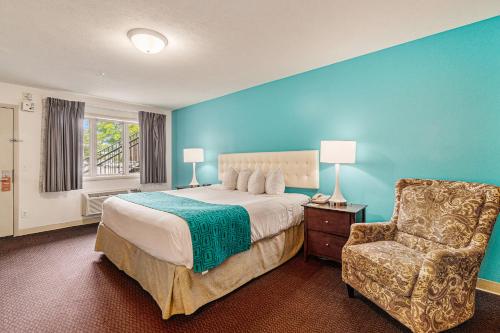 特拉弗斯城特拉弗斯城霍华德约翰逊酒店的一间卧室配有一张大床和一把椅子