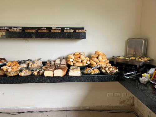 阿帕雷西达Hotel Vila dos Pescadores的架子上堆满了各种面包