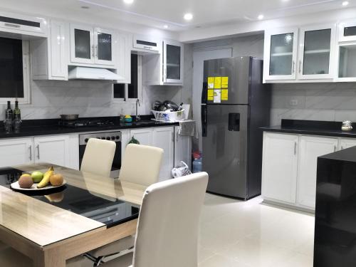 Los ParedonesApartamento en Santo Domingo的厨房配有桌椅和冰箱。