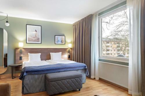 南泰利耶Best Western Plus Skogshöjd的酒店客房设有一张床和一个大窗户