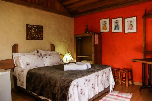 阿尤鲁奥卡Pousada Estalagem Mirante的一间设有床铺的卧室,位于一个拥有橙色墙壁的房间