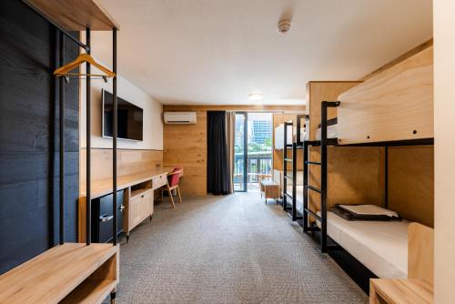 黄金海岸Bunk Surfers Paradise International Backpacker Hostel的宿舍间设有双层床和电视。