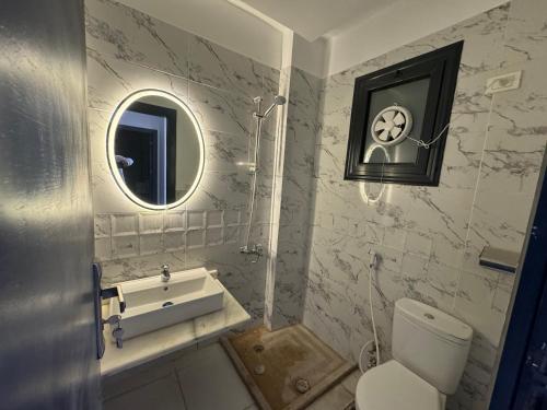 沙姆沙伊赫Montazah seaside homes的一间带卫生间、水槽和镜子的浴室