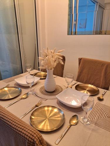 马尼拉La Casa Ysabela - Azure Affordable Staycation, Paranaque Metro Manila的一张餐桌,上面有盘子和银器